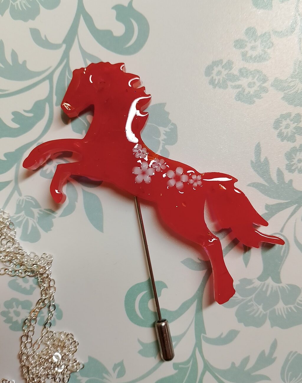 Брошь с красной лошадкой — символом 2026 года